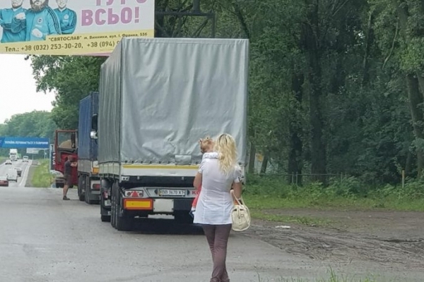 Жінка з дитиною на руках працює повією на трасі біля Львова